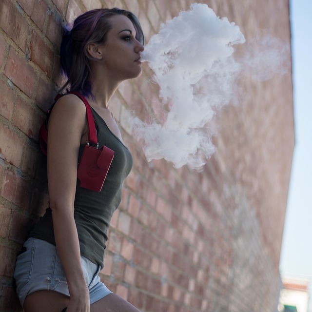 lady vaping standing against wall